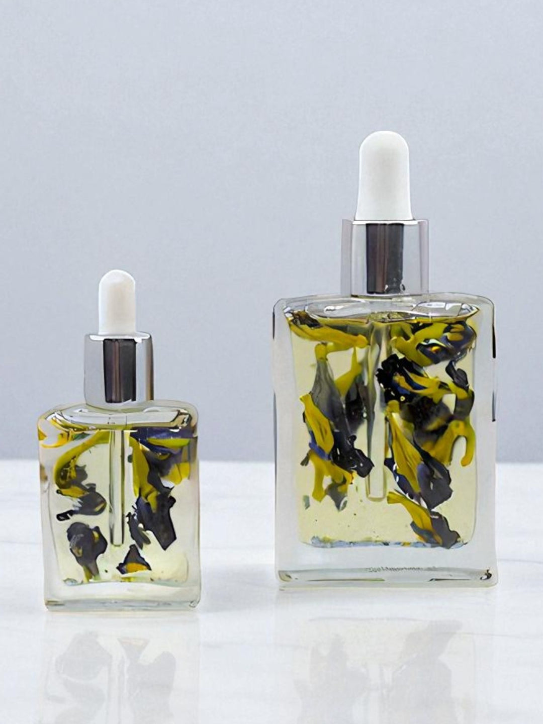 Bottle of Celestial Bloom Oil with butterfly pea flowers by Gaiaé. Botanical massage oil for glowing, soft skin.
