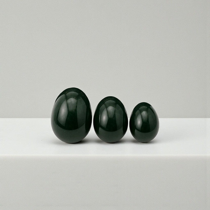 Gaiae Jade Yoni Eggs on a white marble bench and white wall 