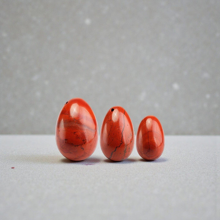 Red Jasper Yoni Egg grey table and background  • Sexual Energy • Root Chakra Grounding • Endurance Stone